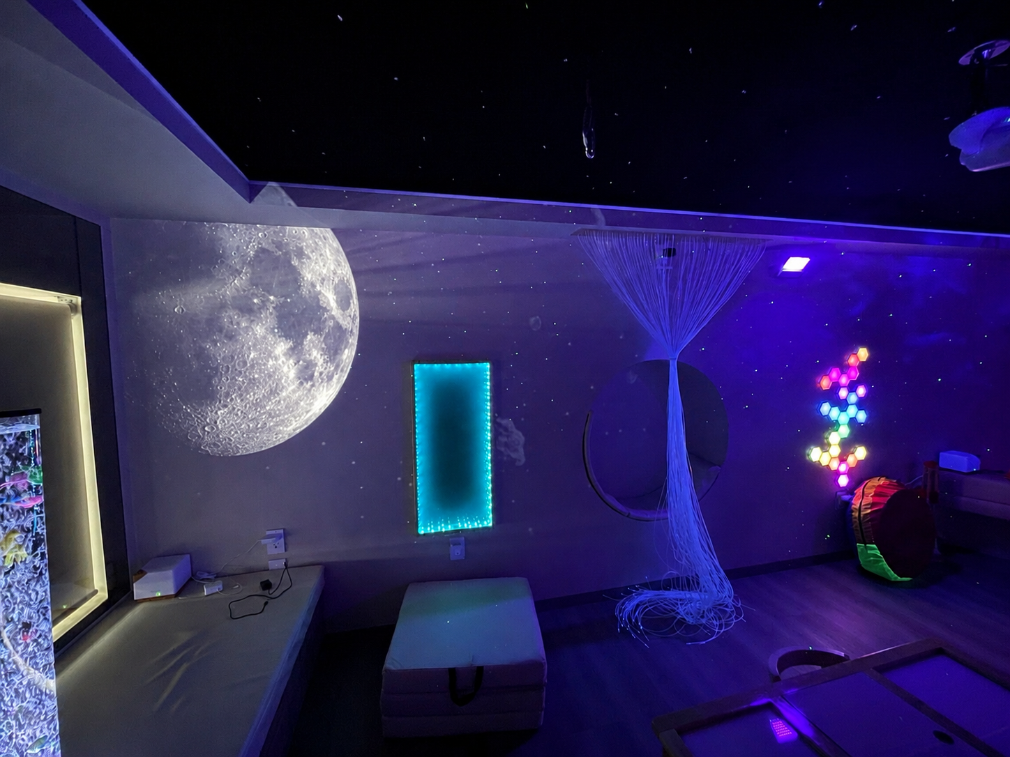 Espacio sensorial con iluminación UV, paneles hexagonales y mesa de luz